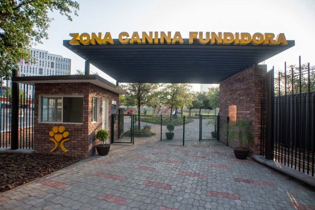 Acceso de la Zona Canina Fundidora con letrero dorado, caseta de ladrillo y reja de entrada