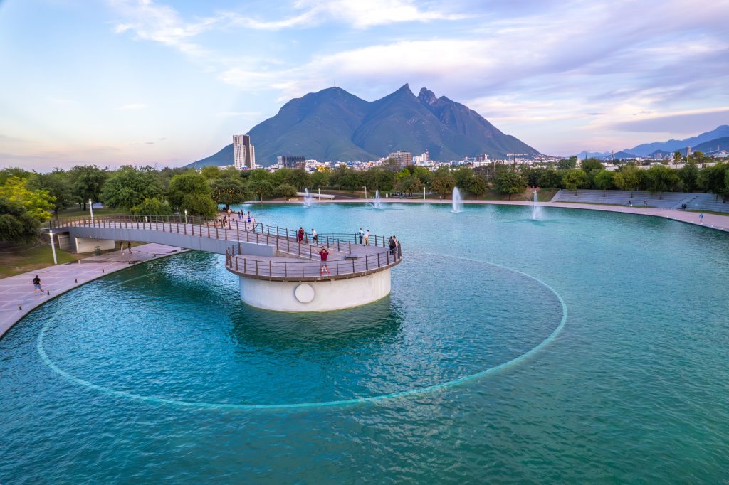 Vista aérea de la laguna del Paseo Santa Lucía con fuentes y el Cerro de la Silla al fondo.